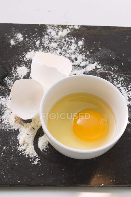 Eggshell and flour on desk — Stock Photo