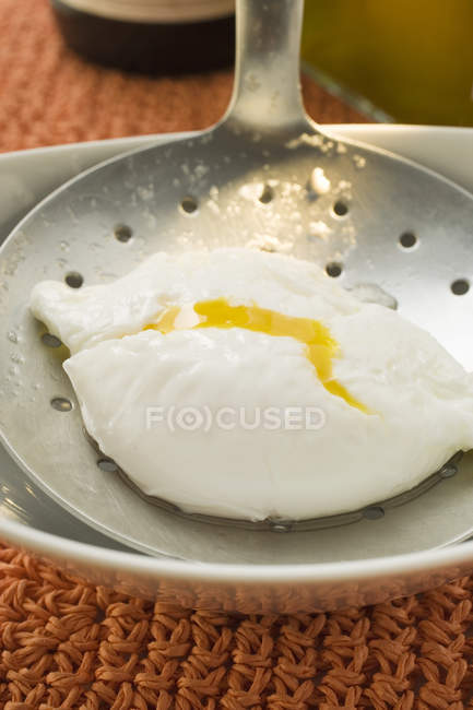 Huevo escalfado en espumadera - foto de stock
