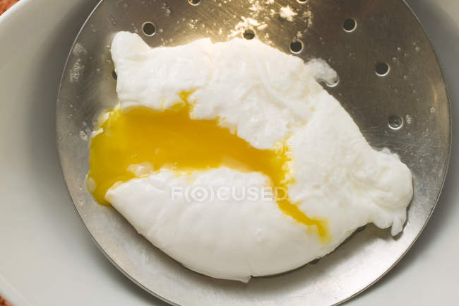 Huevo escalfado en espumadera - foto de stock