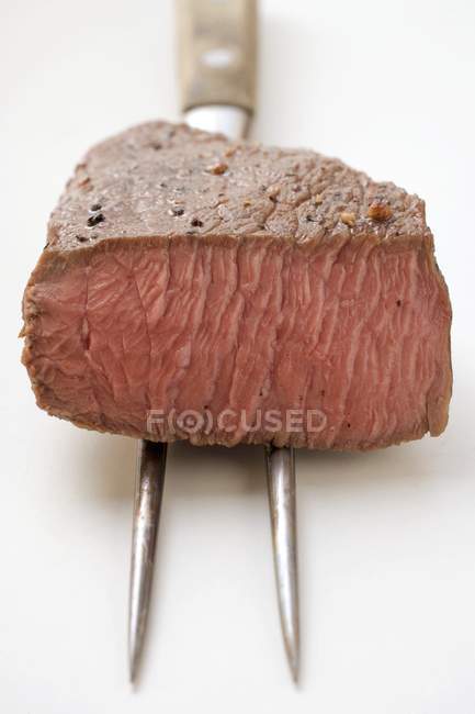Beef steak on meat fork — Stock Photo