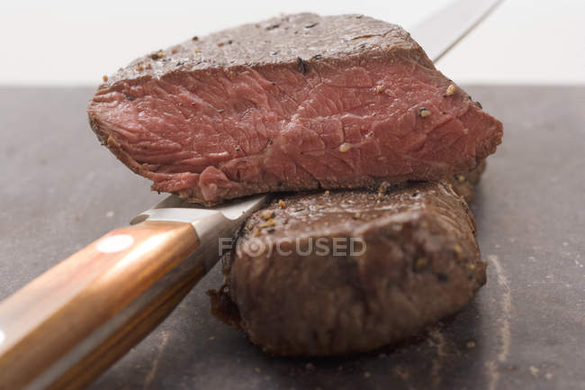 Beef steaks with knife — Stock Photo