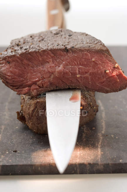 Beef steaks with knife — Stock Photo