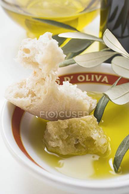 Olive oil in bowl with white bread — Stock Photo