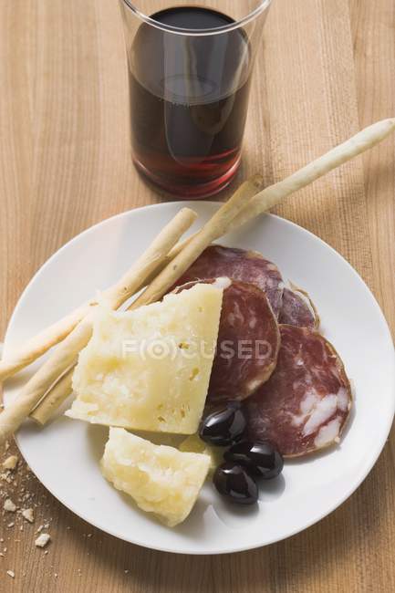 Salame com queijo e grissini no prato — Fotografia de Stock