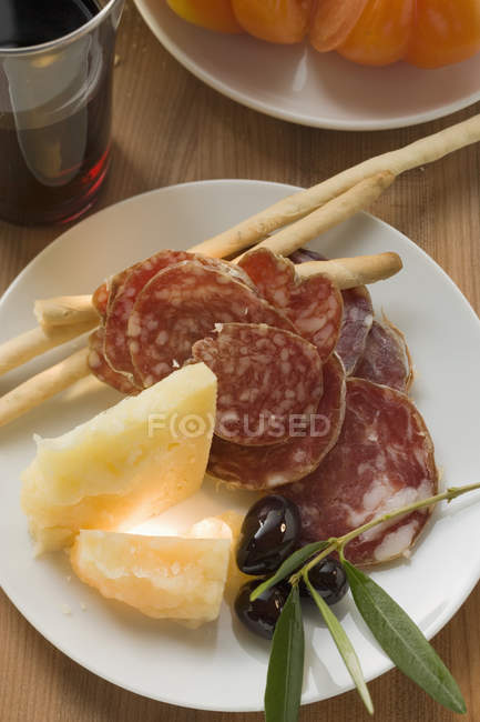 Salame com queijo e grissini no prato — Fotografia de Stock