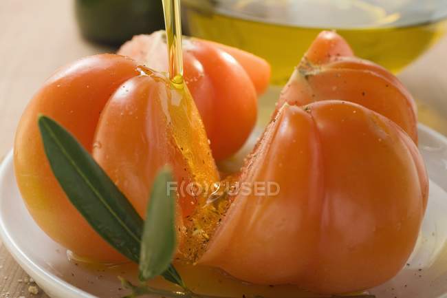 Tomaten mit Olivenöl übergießen — Stockfoto