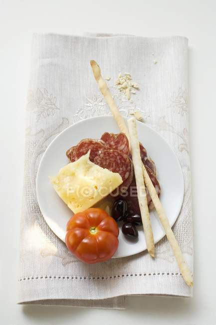 Салями с сыром и гриссини на тарелке — стоковое фото