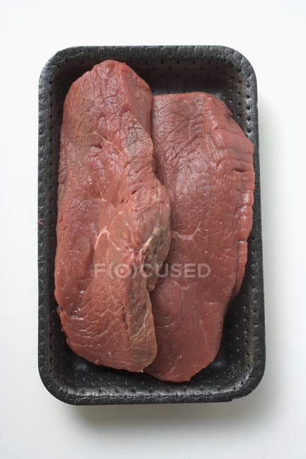 Raw beef sirloin in polystyrene tray — Stock Photo