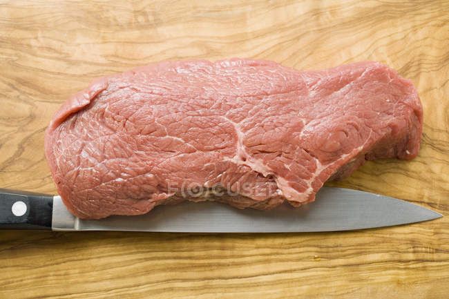 Solomillo de carne cruda con cuchillo - foto de stock