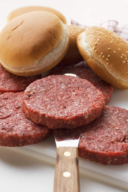 Hamburger crudi e panini di hamburger — Foto stock