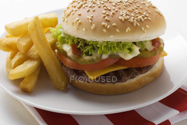 Cheeseburger with mayonnaise and chips — Stock Photo