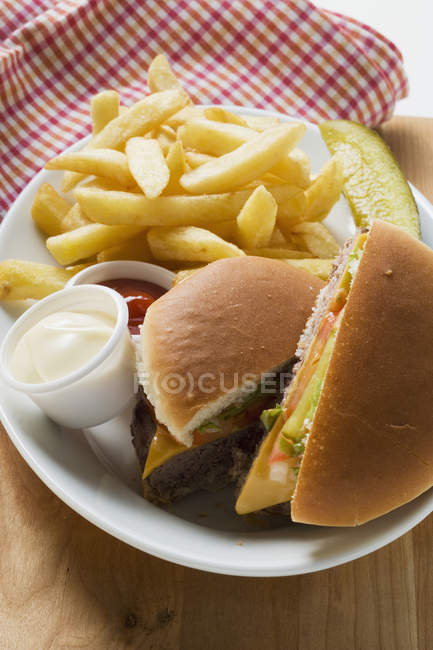 Halbierter Cheeseburger mit Pommes — Stockfoto