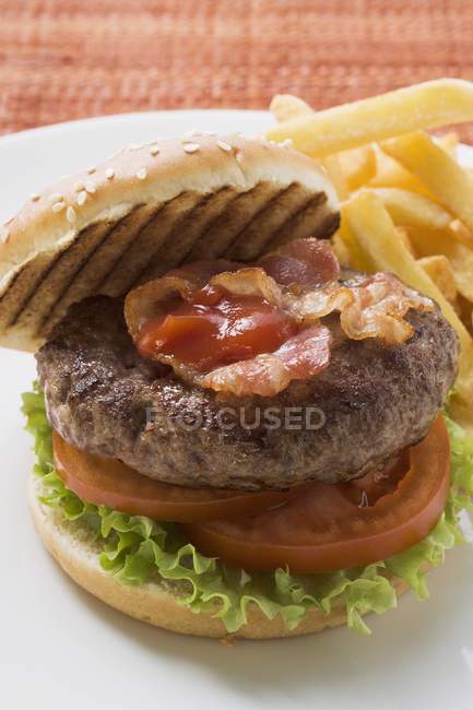 Hamburger with bacon and chips — Stock Photo