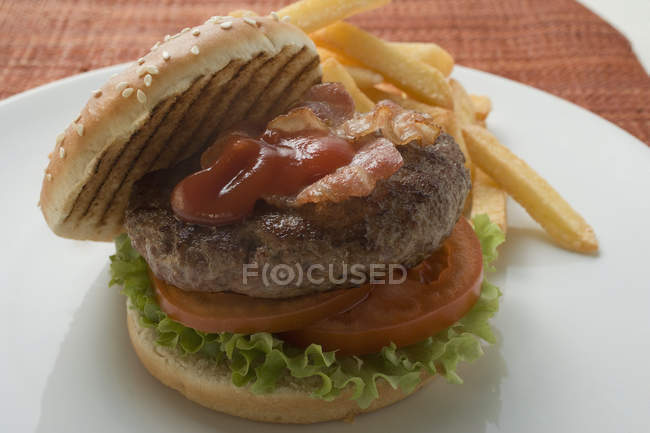Hamburger with bacon and chips — Stock Photo