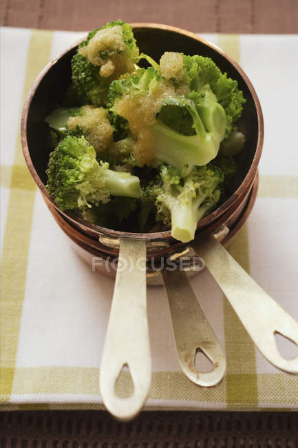 Broccoli with buttered breadcrumbs in pan over towel — Stock Photo