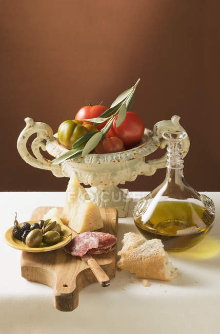 Oliven mit Wurst, Parmesan, Öl, Weißbrot und Tomaten — Stockfoto