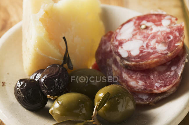 Оливки с нарезанной колбасой и пармезан — стоковое фото