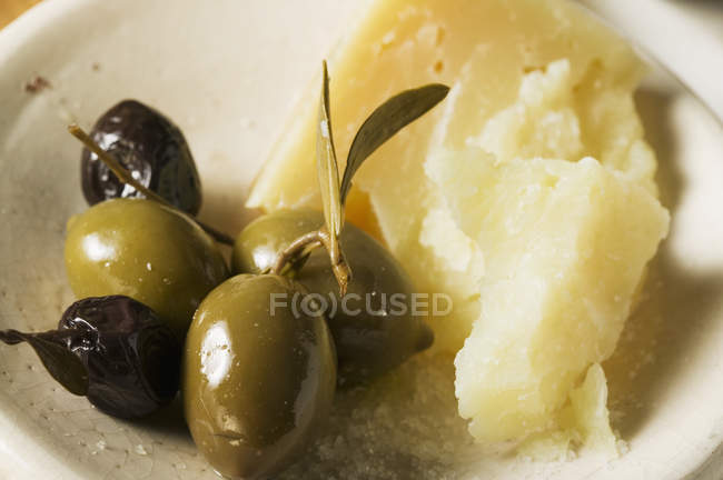 Крупный план оливок и сыра пармезан — стоковое фото