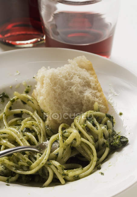 Linguine with pesto and white bread — Stock Photo