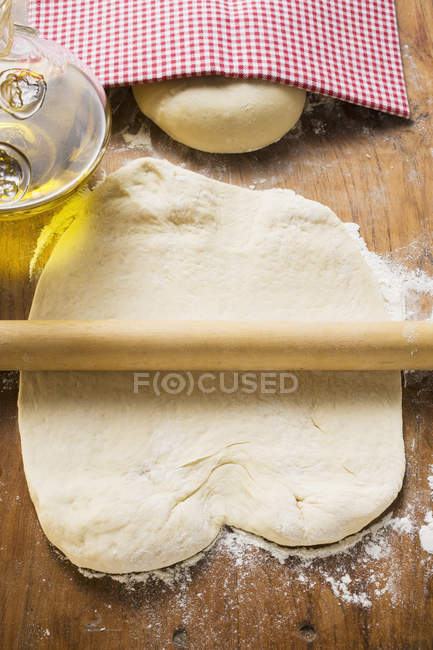 Dough, rolling pin and olive oil — Stock Photo