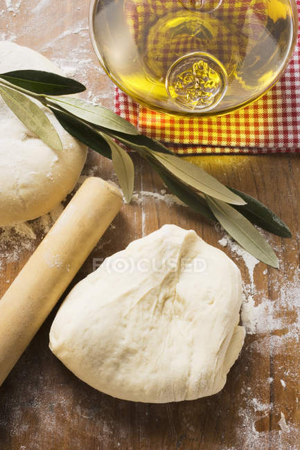 Pâte, rouleau à pâtisserie et huile d'olive — Photo de stock