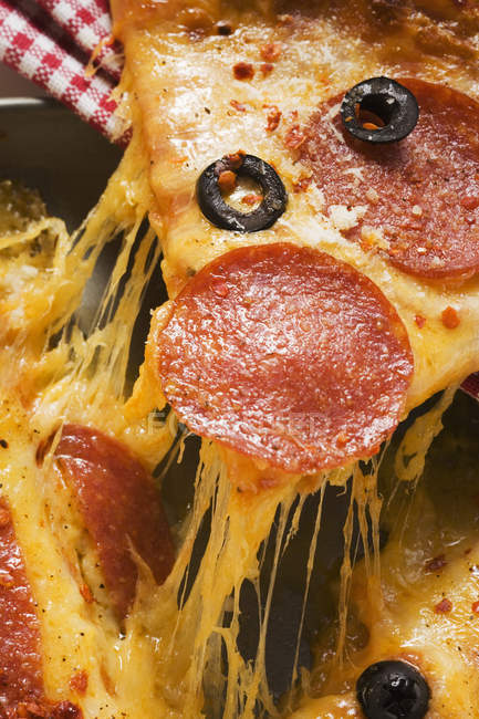 Pizza con salami, queso y aceitunas - foto de stock