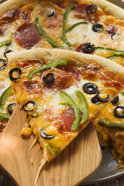 Pezzo di pizza con peperoni e olive — Foto stock