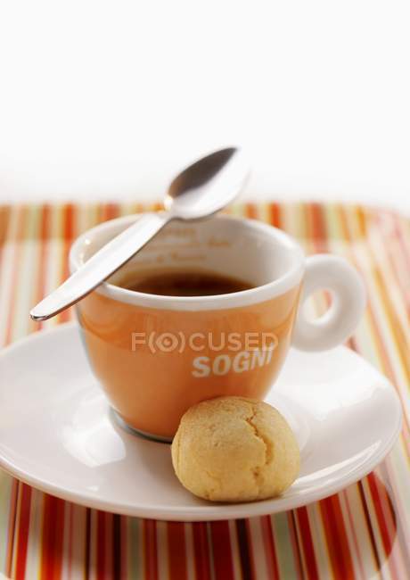 Closeup view of Espresso cup with spoon and sweet ball on saucer — Stock Photo