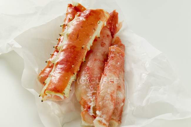 Closeup view of king crab legs on white wrapping paper — Stock Photo