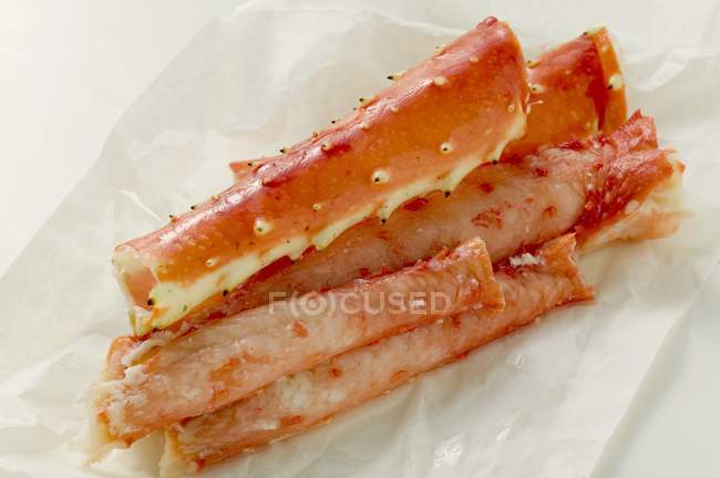 Closeup view of king crab legs on white wrapping paper — Stock Photo