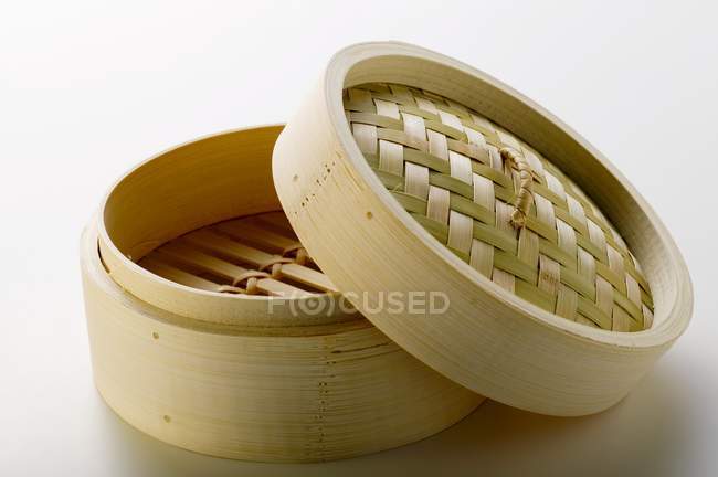 Vue rapprochée d'un vapeur en bambou ouvert sur une surface blanche — Photo de stock