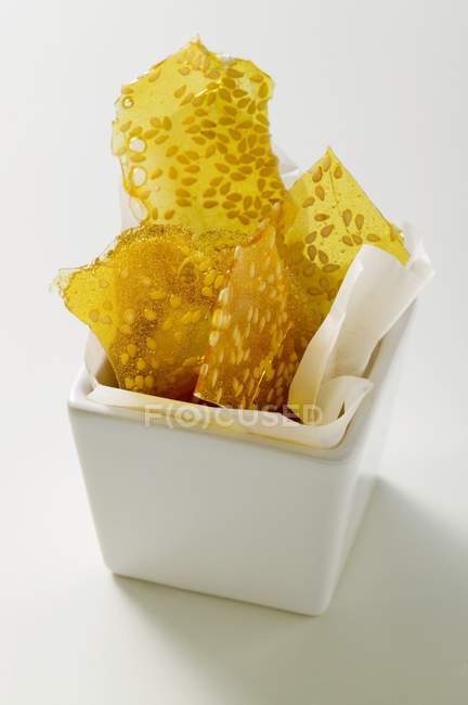 Closeup view of candied sesame seeds in square white bowl — Stock Photo