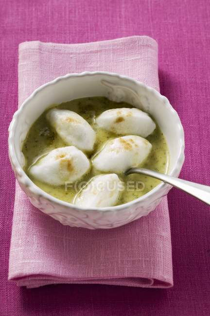 Poached meringues with pistachio sauce — Stock Photo