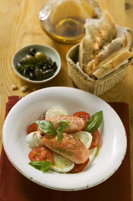 Tomates com mussarela, salmão e manjericão — Fotografia de Stock