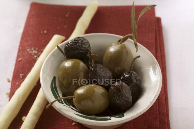 Schwarze und grüne Oliven mit Grissini — Stockfoto