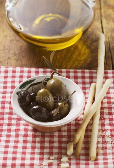 Aceitunas con grissini y aceite de oliva - foto de stock
