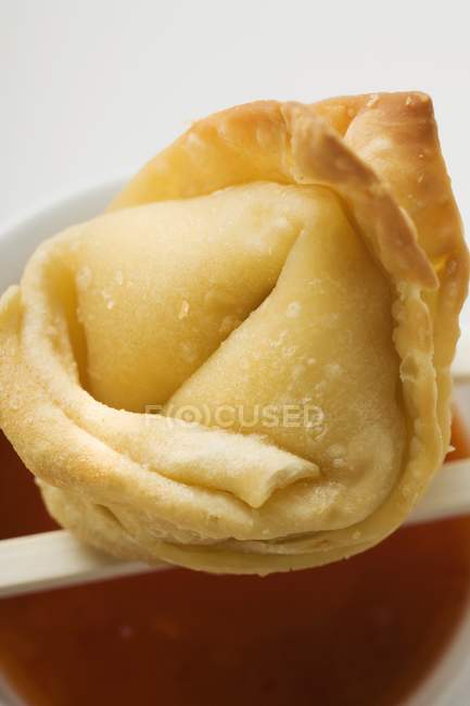 Closeup view of one deep-fried Wonton with sweet and sour sauce — Stock Photo
