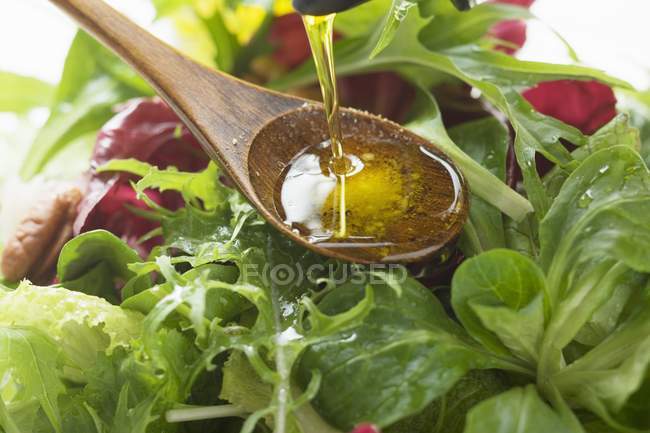 Olivenöl in Salat gießen — Stockfoto