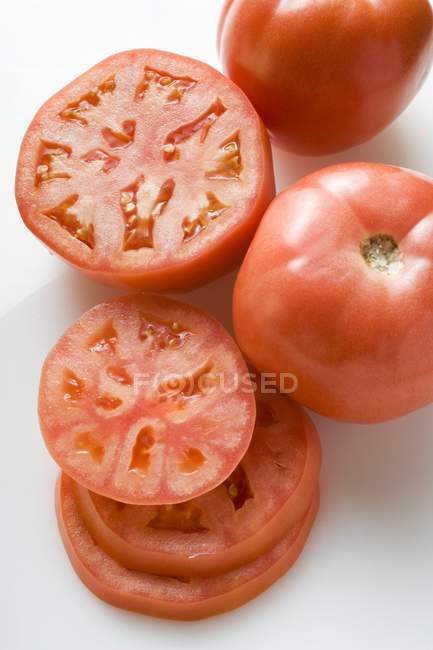 Половинчатые и нарезанные помидоры — стоковое фото