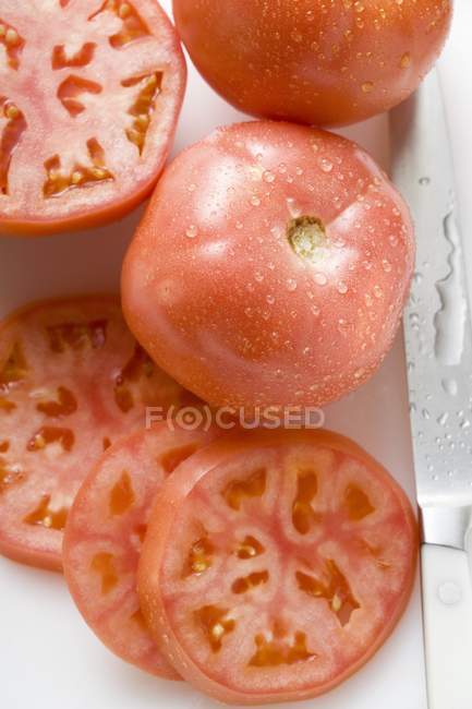 Половинчатые и нарезанные помидоры — стоковое фото