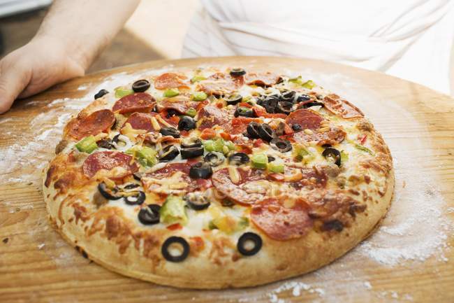 Человек с пиццей пепперони — стоковое фото