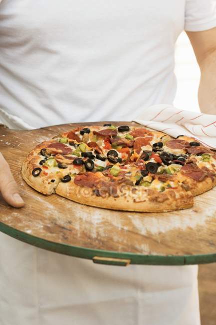 Homem segurando pizza pepperoni — Fotografia de Stock
