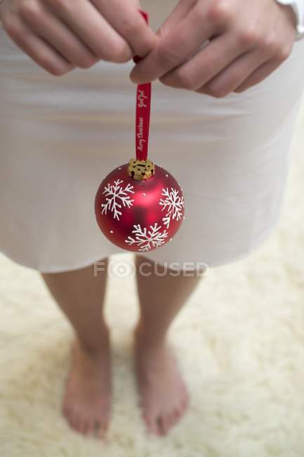 Femme tenant une boule de Noël — Photo de stock