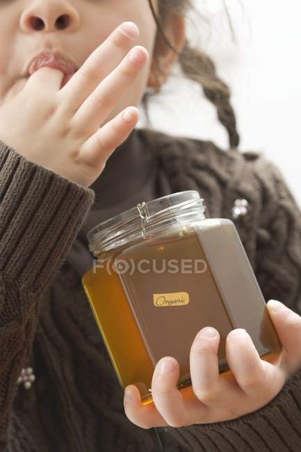 Ragazza degustazione miele — Foto stock