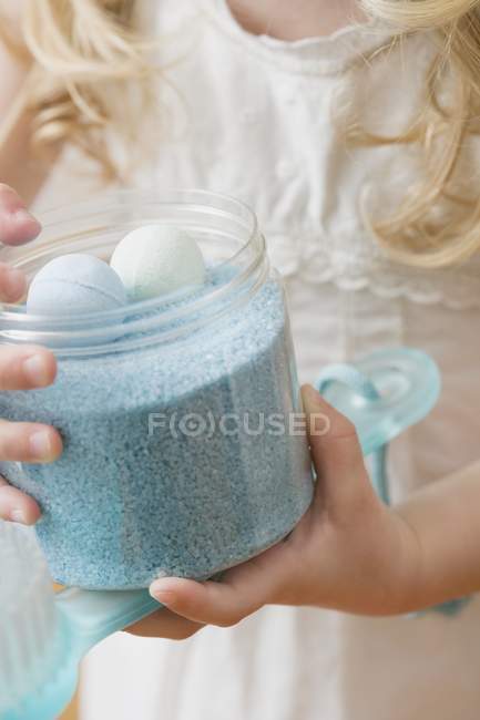 Cropped view of girl holding container of bath products — Stock Photo