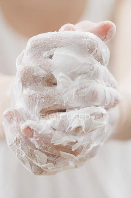 Nahaufnahme von mit Creme beschichteten Händen — Stockfoto