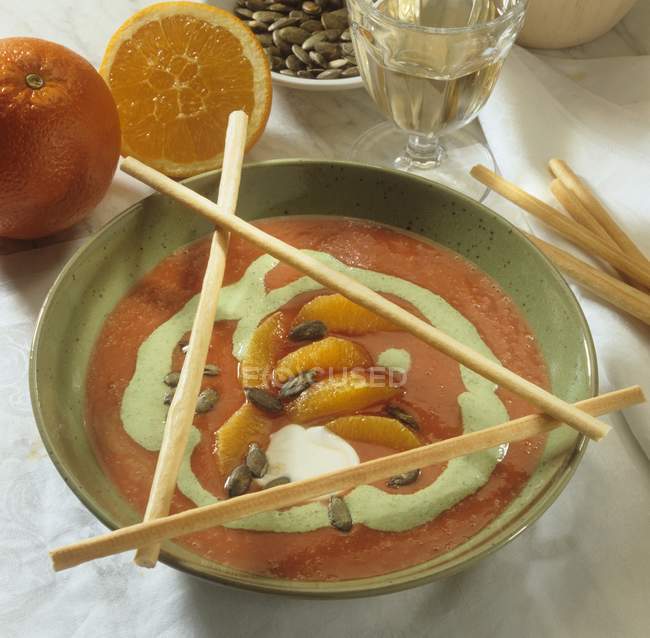 Sopa de tomate crema con segmentos de naranja - foto de stock