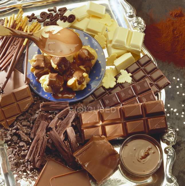 Varios tipos de chocolate y profiteroles - foto de stock