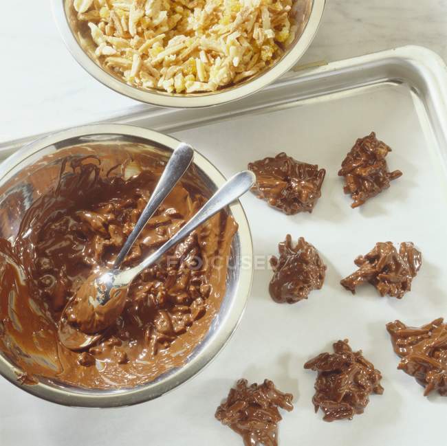 Vista dall'alto dei grappoli di cioccolato e mandorle con ingredienti sulla teglia — Foto stock