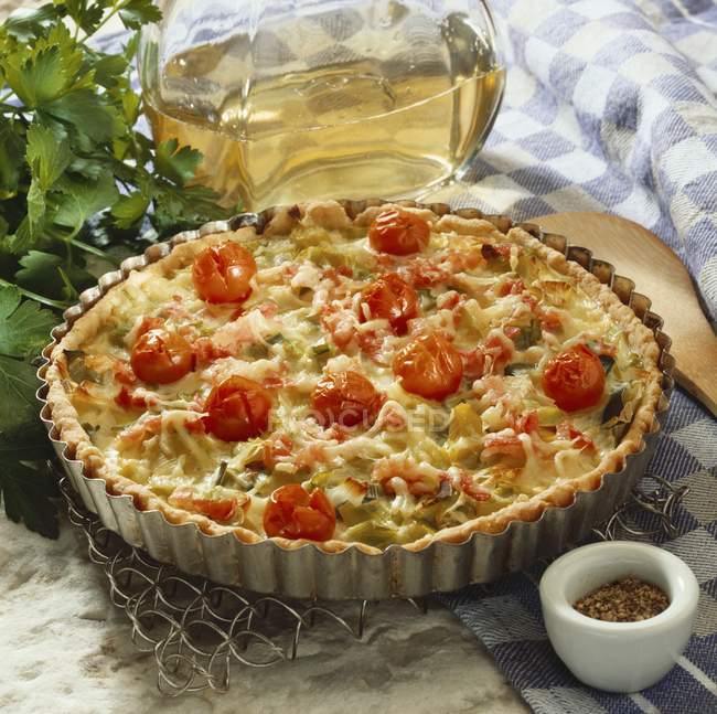 Vegetable quiche on wire rack over wooden table — Stock Photo